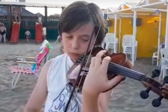 con su musica a la playa: conoce al nene que, con su violin, sorprende a los turistas en ?la feliz?