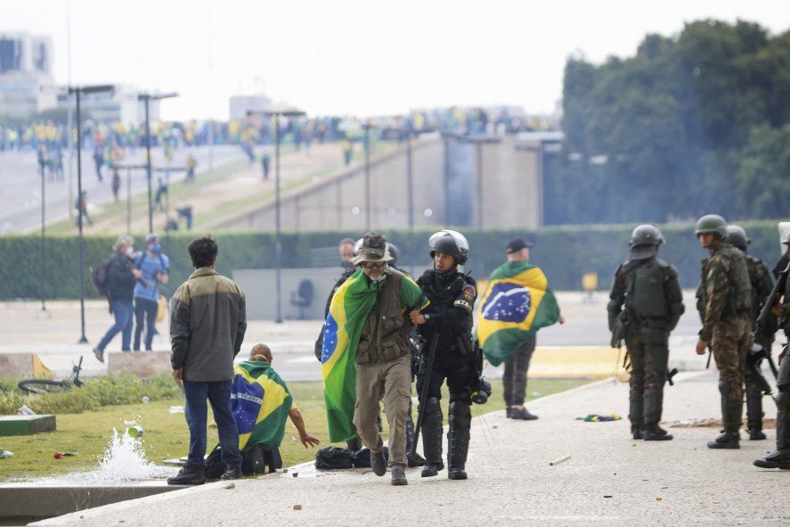 Fuerzas de seguridad detienen a un seguidor de Bolsonaro afuera del Congreso Nacional de Brasil.