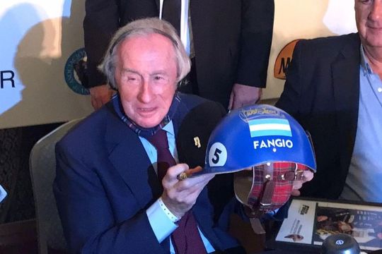El casco de Fangio en manos de Sir Jackie Stewart, la gran leyenda de la Fórmula 1 no dejó más que elogios para el de Balcarce.