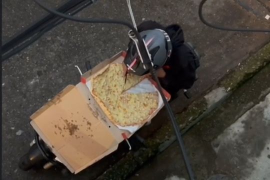 delivery es captado comiendose una porcion y reacomodando la pizza