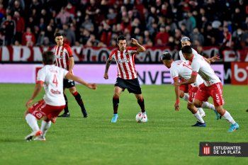 Emmanuel Mas lleva la pelota ante la mirada de los jugadores de Argentinos Juniors (Prensa EDLP)
