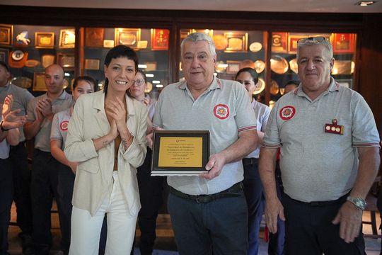 Mayra Mendoza y la placa conmemorativa para los Bomberos Voluntarios de Quilmes.