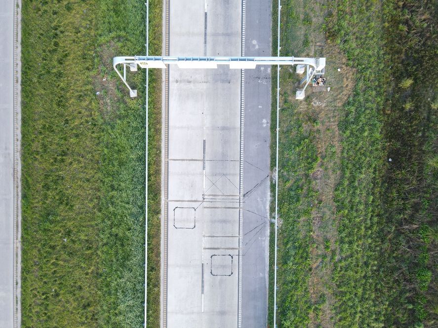 Los sensores que pesan los vehículos en movimiento están debajo del asfalto y las cámaras de video están en el arco metálico.